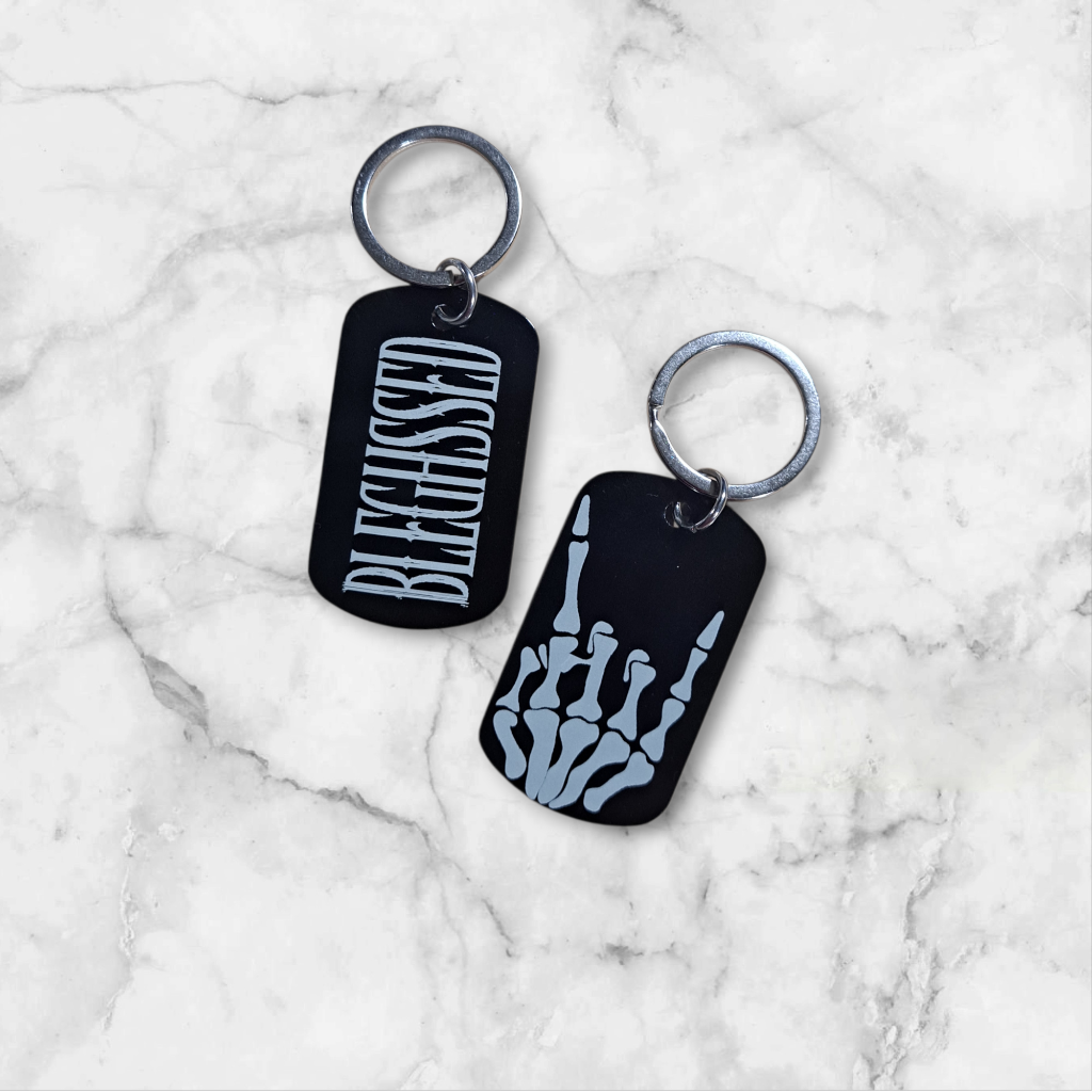 Black anodized aluminum dog tag
engraved with BLEGHSSED on one side
and the metal skeleton hand on the other