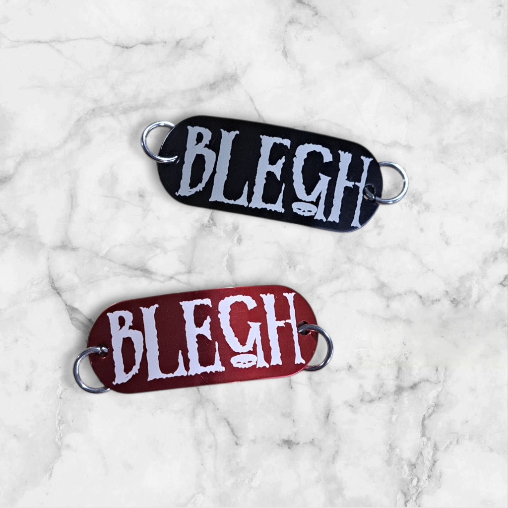 Bent aluminum lacing tag with Blegh engraved on it. Available in Black or Red