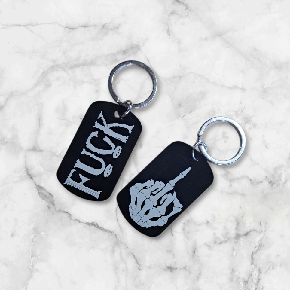 Black anodized aluminum dog tag
engraved with FUCK on one side
and the middle finger skeleton hand on the other