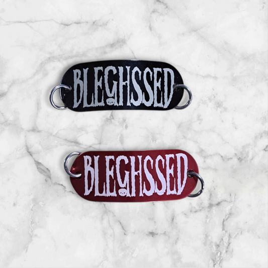 Bent aluminum lacing tag with BLEHSSED engraved on it. Available in Black or Red