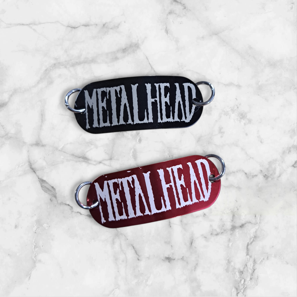 Bent aluminum lacing tag with Metalhead engraved on it. Available in Black or Red